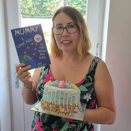 Charlotte Rowlands holding a birthday card and birthday cake
