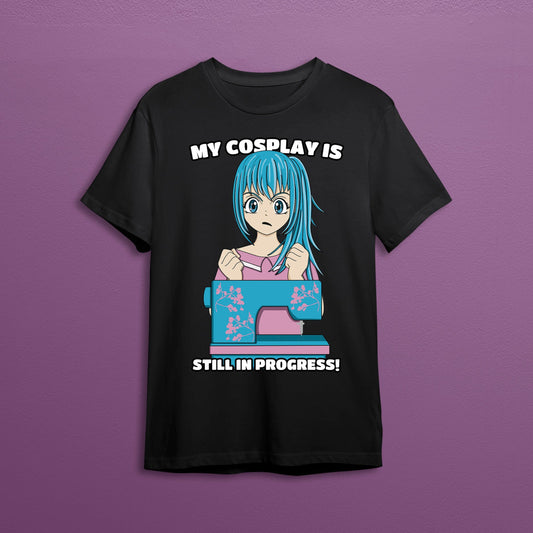 Funny anime girl sewing graphic on a black t-shirt. The text on the shirt reads "my cosplay is still in progress"