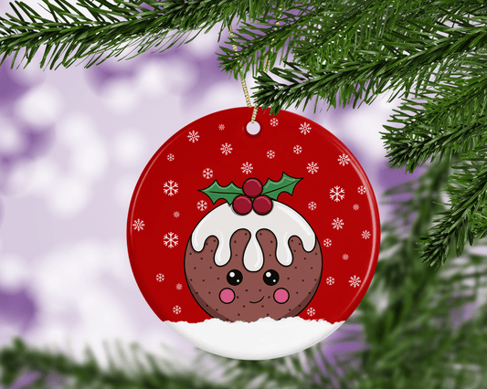 A round ceramic Christmas decoration to hang from a tree. Has a hand drawn illustration of a cute figgy pudding with a red snowy background.