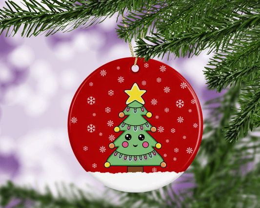 A round ceramic Christmas decoration to hang from a tree. Has a hand drawn illustration of a cute Christmas tree with smiley face and with a red snowy background.