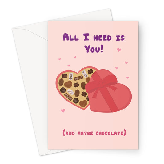 All I need is you greeting card with heart shaped chocolate box and pink hearts on a pastel background