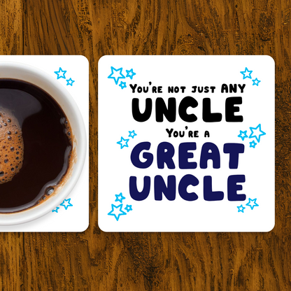 Coaster with 'You're not just any uncle, you're a great uncle' text next to a cup of coffee on a wooden surface