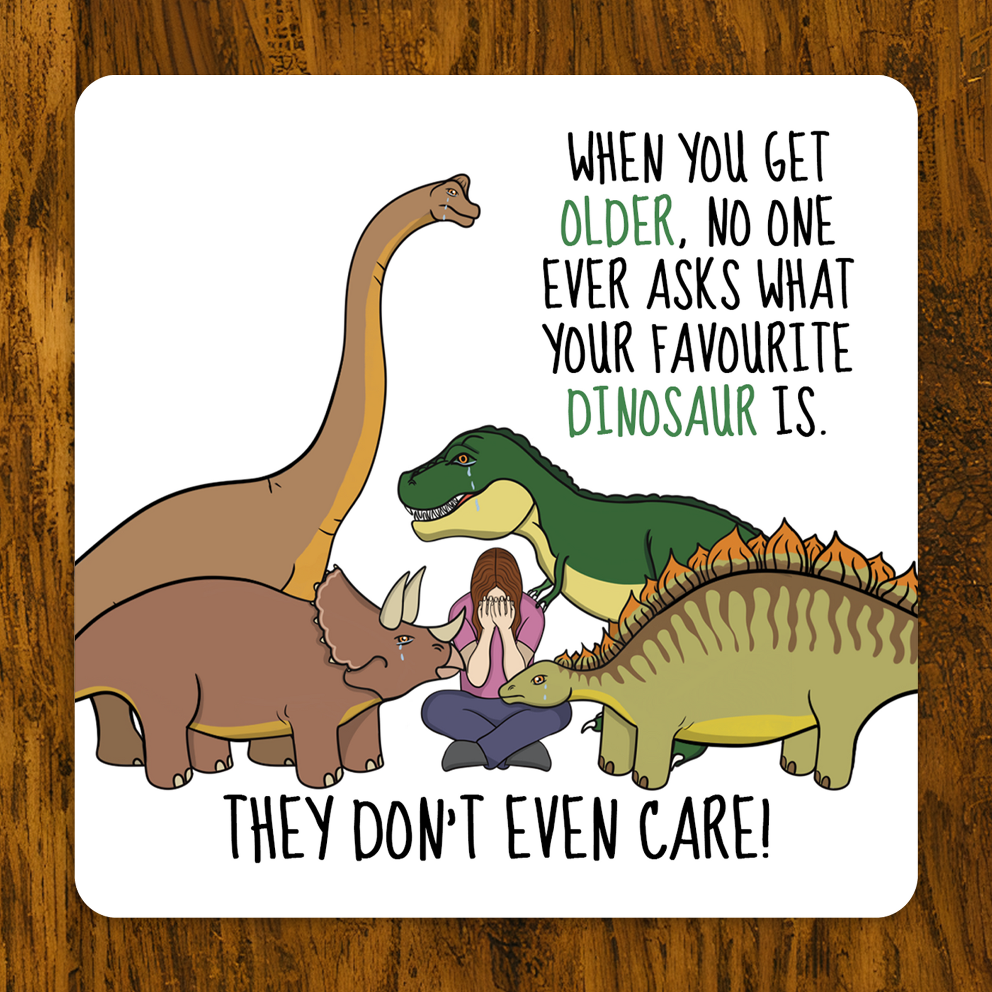 Cartoon illustration of a person surrounded by dinosaurs with humorous text on a wooden background