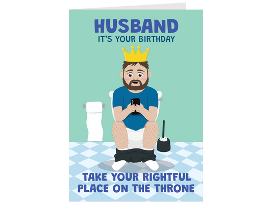 A humorous birthday card featuring a cartoon illustration of a bearded man sitting on a toilet using his phone, wearing a gold crown. The card has a light teal background with blue text reading 'HUSBAND IT'S YOUR BIRTHDAY' at the top and 'TAKE YOUR RIGHTFUL PLACE ON THE THRONE' at the bottom.