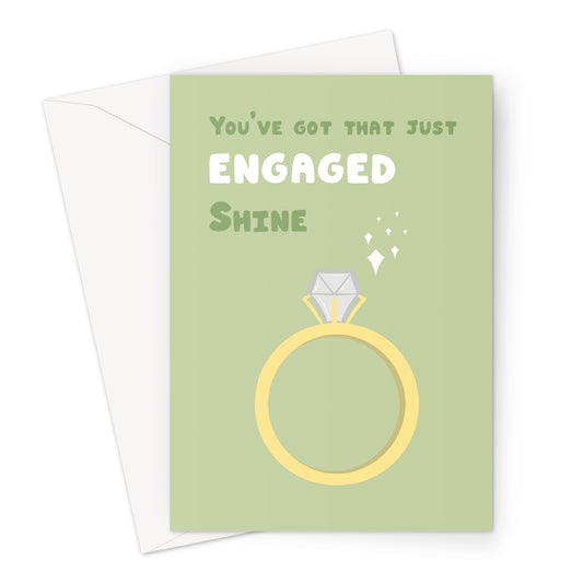 Just engaged greeting card with illustrated gold ring and sparkles on a sage green background