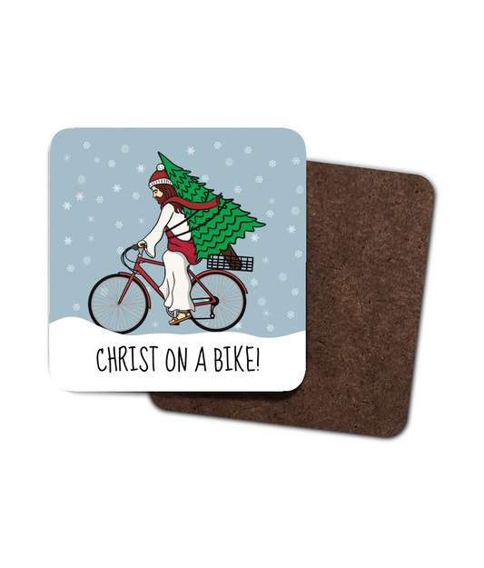 Funny Christmas coaster with Christ riding a bike carrying a Christmas tree and text “Christ on a Bike”